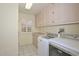 Bright laundry room featuring a side-by-side washer and dryer, neutral cabinets, and a window for natural light at 14617 W Windcrest Dr, Sun City West, AZ 85375