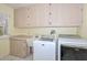 Laundry room with washer, dryer, and ample cabinet space at 14617 W Windcrest Dr, Sun City West, AZ 85375
