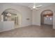 Inviting living room featuring tile floors, ceiling fan, neutral walls, archway entrance to the kitchen, and entrance to the front door at 14617 W Windcrest Dr, Sun City West, AZ 85375