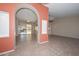 Bright living room featuring tile floors, ceiling fan, neutral walls, archway entrance, and sliding glass door to the outside at 14617 W Windcrest Dr, Sun City West, AZ 85375