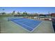 Close up on a pristine blue tennis court in a well-maintained community at 14617 W Windcrest Dr, Sun City West, AZ 85375