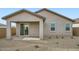 Exterior shot of the house showcasing a covered patio, gravel landscaping, and a neutral color scheme at 14968 W Hackamore Dr, Surprise, AZ 85387