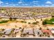 Expansive aerial view of a desert community with uniform housing and community golf course at 15558 W Big Sky Dr, Surprise, AZ 85374