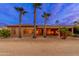 Back exterior view of home featuring a covered patio and well-manicured desert landscaping at 15558 W Big Sky Dr, Surprise, AZ 85374