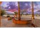 Stunning backyard features a fire pit, decorative rock landscaping, and mature trees at 15558 W Big Sky Dr, Surprise, AZ 85374