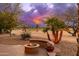 Beautiful backyard with a cozy fire pit area surrounded by lush desert landscaping at 15558 W Big Sky Dr, Surprise, AZ 85374