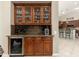 Stylish bar area with custom cabinets, a wine fridge, and granite countertops at 15558 W Big Sky Dr, Surprise, AZ 85374