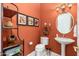 Charming powder room with an pedestal sink, decorative mirror, and unique shelving and artwork at 15558 W Big Sky Dr, Surprise, AZ 85374