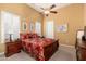 Bright bedroom featuring a tray ceiling, shutters, and a beautiful wood-framed bed at 15558 W Big Sky Dr, Surprise, AZ 85374