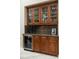 Elegant butler pantry featuring glass-front cabinets, a wine rack, granite countertops, and a built-in wine refrigerator at 15558 W Big Sky Dr, Surprise, AZ 85374