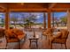 Inviting covered patio with comfortable seating and outdoor fireplace overlooking the meticulously landscaped backyard at 15558 W Big Sky Dr, Surprise, AZ 85374
