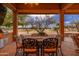 Outdoor dining area features a built-in BBQ and a dining table with seating for eight under a covered patio at 15558 W Big Sky Dr, Surprise, AZ 85374