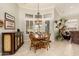 Cozy dining area with a round wooden table, decorative light fixture, and access to outdoor space at 15558 W Big Sky Dr, Surprise, AZ 85374