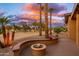 Inviting outdoor patio with a stylish fire pit and lush desert landscaping at 15558 W Big Sky Dr, Surprise, AZ 85374