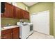 Functional laundry room with ample cabinet space, a sink, and modern appliances at 15558 W Big Sky Dr, Surprise, AZ 85374