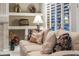 Bright living room featuring a neutral sofa, decorative pillows, built-in shelves, and a large window with blinds at 15558 W Big Sky Dr, Surprise, AZ 85374