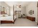 Bright bedroom featuring a four poster bed, ceiling fan, neutral walls, and comfortable seating area at 15558 W Big Sky Dr, Surprise, AZ 85374