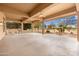 Spacious covered patio with outdoor kitchen, ceiling fans and view of landscaped backyard at 15558 W Big Sky Dr, Surprise, AZ 85374