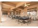 A covered patio with ample seating, ceiling fans, and heater, providing a comfortable outdoor living space at 15558 W Big Sky Dr, Surprise, AZ 85374