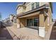 Exterior view of home with covered back patio and sliding glass door leading to landscaped backyard at 16213 W Soft Wind Dr, Surprise, AZ 85387