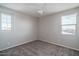 Bright bedroom featuring neutral walls, plush carpet, a ceiling fan, and two windows at 16213 W Soft Wind Dr, Surprise, AZ 85387