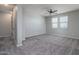 Spacious bedroom with a ceiling fan, plush carpeting, and windows for plenty of natural light at 16213 W Soft Wind Dr, Surprise, AZ 85387