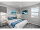 Bedroom featuring a bed with blue and white coverings, lamps, and decorated walls at 16213 W Soft Wind Dr, Surprise, AZ 85387