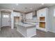 Bright kitchen with white cabinets, an island, stainless appliances and wood-look flooring at 16213 W Soft Wind Dr, Surprise, AZ 85387