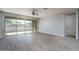 Neutral living room with sliding glass doors, ceiling fan, and wood-look tile flooring at 16213 W Soft Wind Dr, Surprise, AZ 85387