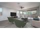 Bright living room features a ceiling fan, modern furniture, and sliding glass doors to the outdoor space at 16213 W Soft Wind Dr, Surprise, AZ 85387