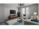 Cozy living room boasts a large window, ceiling fan, and modern decor creating a comfortable atmosphere at 16213 W Soft Wind Dr, Surprise, AZ 85387