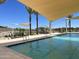 Community swimming pool with lounge chairs and sun shades in the background at 16213 W Soft Wind Dr, Surprise, AZ 85387