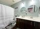 Bathroom with double vanity, tile floors, and shower and tub with white shower curtain at 17311 N Kimberly Way, Surprise, AZ 85374