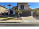 Charming two-story home featuring a two-car garage, tiled roof, palm trees, and manicured landscaping at 17311 N Kimberly Way, Surprise, AZ 85374