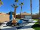Relaxing backyard featuring a hot tub, lounge furniture, desert landscaping, and artificial grass at 17311 N Kimberly Way, Surprise, AZ 85374