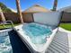 A relaxing inground hot tub with clear blue water is surrounded by palm trees and lush artificial grass at 17311 N Kimberly Way, Surprise, AZ 85374