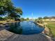 Scenic view of a pond with a fountain, bordered by rocks and greenery, creating a peaceful atmosphere at 17311 N Kimberly Way, Surprise, AZ 85374