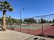 Community tennis court surrounded by green landscaping and a secure fence under a clear blue sky at 17311 N Kimberly Way, Surprise, AZ 85374