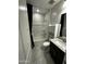 Bathroom with a shower-tub combo, modern vanity, and convenient shelving for a functional and stylish design at 18231 W Paraiso Dr, Surprise, AZ 85387