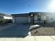 Charming single-story home featuring a two-car garage, desert landscaping, and covered porch with stone accents at 18231 W Paraiso Dr, Surprise, AZ 85387