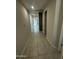 A long hallway with tile floors and several doors leading to different rooms at 18231 W Paraiso Dr, Surprise, AZ 85387