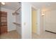 Walk-in closet featuring built-in shelving and a view of the bathroom at 18835 N Palomar Dr, Sun City West, AZ 85375