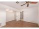 Bedroom with ceiling fan, wood-look floors, and closet with built-in shelving at 2038 S 221St Ave, Buckeye, AZ 85326