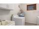 Well-equipped laundry room features washer, dryer, sink and ample cabinet storage at 2038 S 221St Ave, Buckeye, AZ 85326