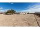 Backyard exterior showcasing a spacious dirt lot and a white house at 2038 S 221St Ave, Buckeye, AZ 85326