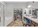 Bathroom showcasing a tub, walk-in closet, double sinks, and modern fixtures at 2213 E Constance Way, Phoenix, AZ 85042