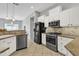 Modern kitchen features stainless steel appliances, tile floors, and granite countertops at 2213 E Constance Way, Phoenix, AZ 85042