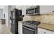Contemporary kitchen featuring stainless steel appliances, gas range, stone countertops and updated cabinetry at 2213 E Constance Way, Phoenix, AZ 85042
