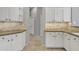 White kitchen featuring stone countertops, custom cabinets, tile backsplash, and tile flooring at 2213 E Constance Way, Phoenix, AZ 85042