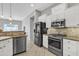Well-lit kitchen boasting modern appliances, granite countertops, white cabinets, and an open layout at 2213 E Constance Way, Phoenix, AZ 85042